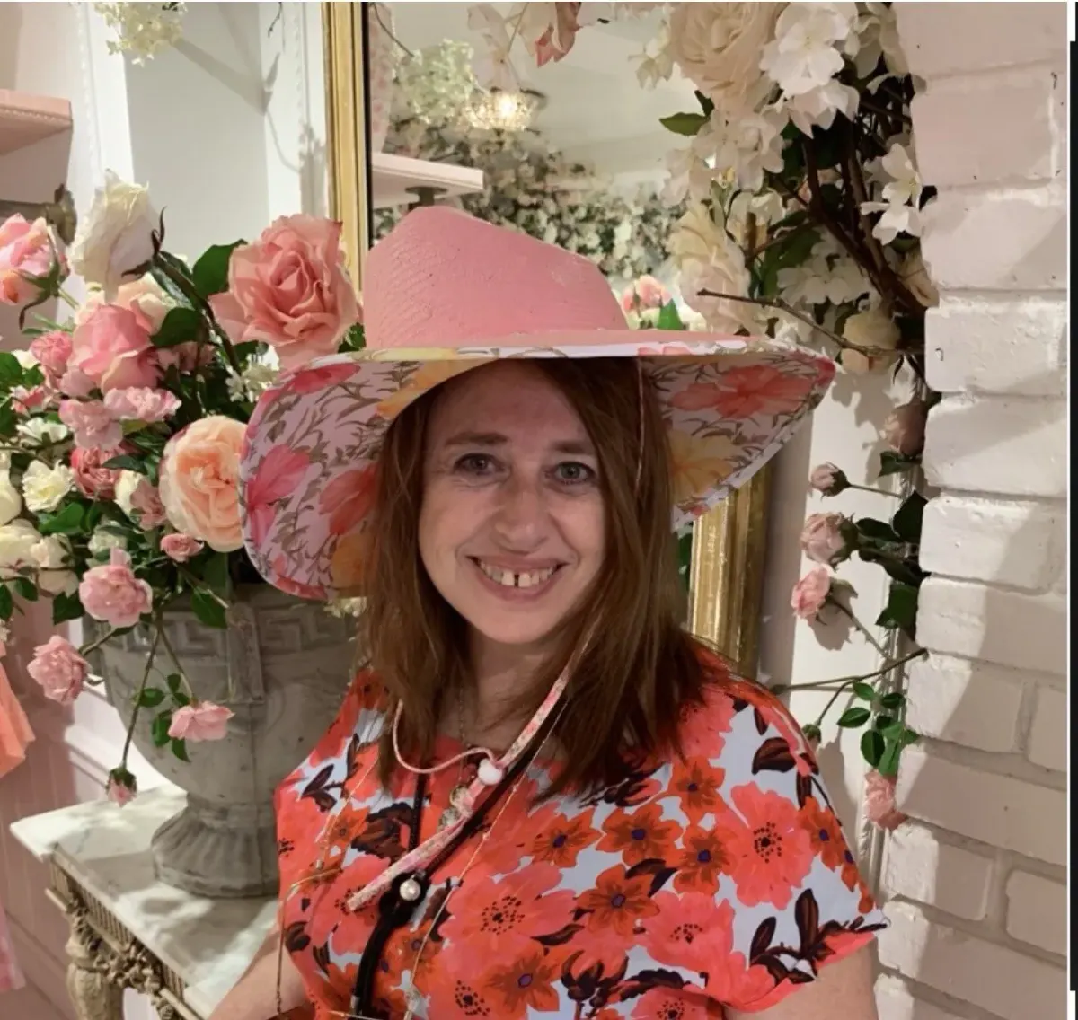 Woman in a pink floral hat and bright floral shirt in a floral indoor setting for a page on fairy-tale archetypes Woman in a pink floral hat and bright floral shirt in a floral indoor setting for a page on fairy-tale archetypes