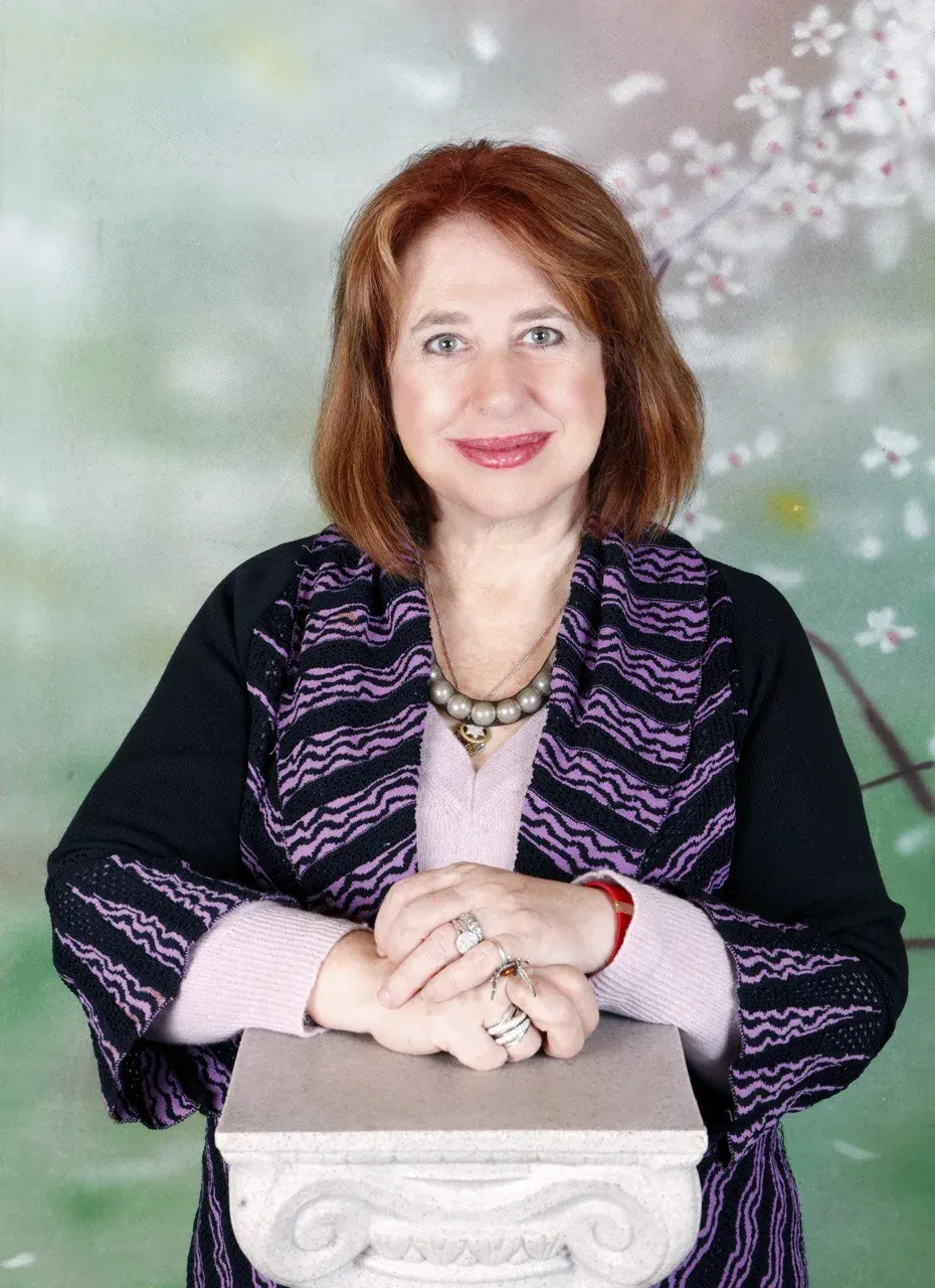 Smiling red-haired woman in a patterned cardigan and pearl necklace on a soul purpose coaching page Smiling red-haired woman in a patterned cardigan and pearl necklace on a soul purpose coaching page